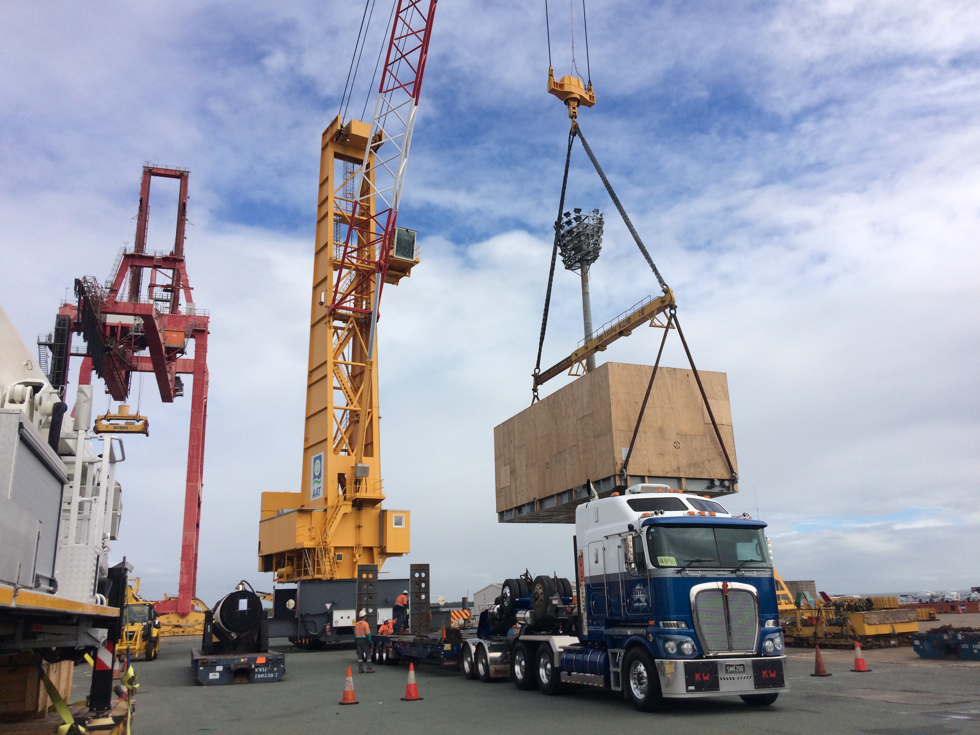 A crane moving cargo onto a truck.